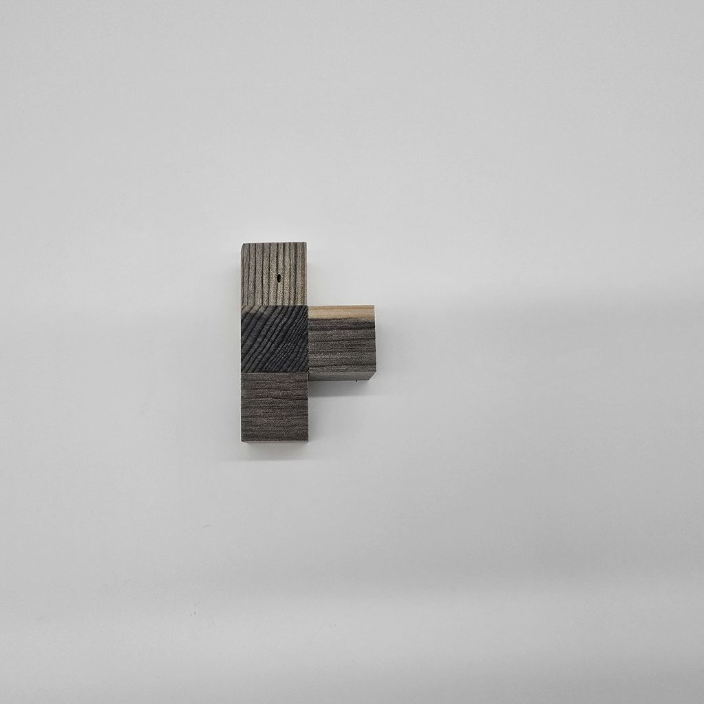 Minimalist wooden blocks arranged on a white surface.