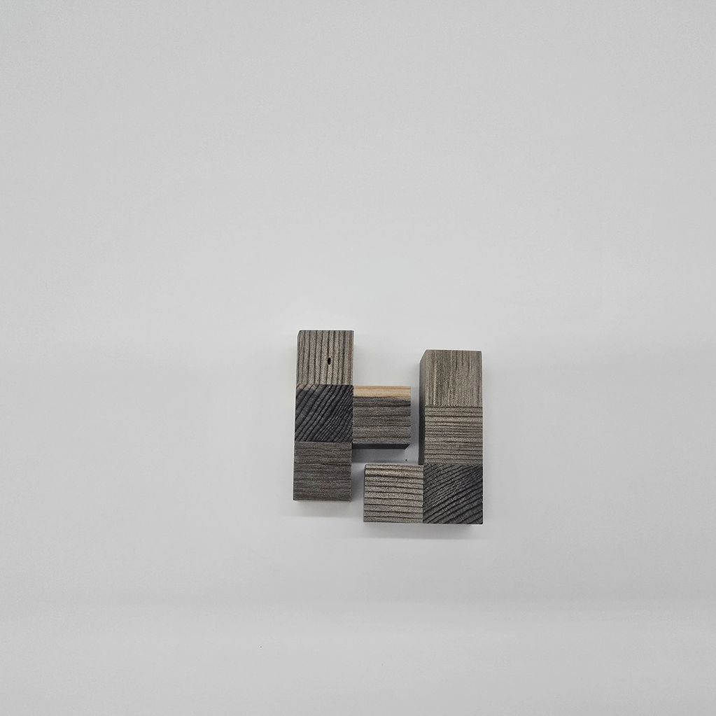 Wooden blocks arranged in a geometric pattern on a white surface.
