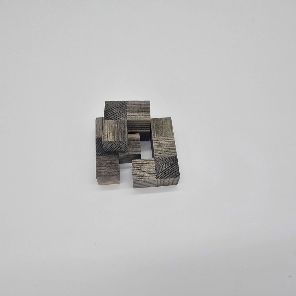 Wooden puzzle blocks arranged in a geometric pattern on a white surface.