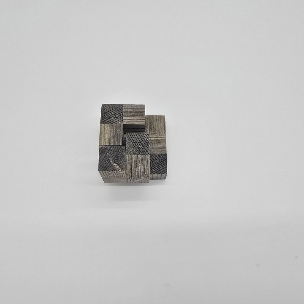 A small wooden block puzzle on a plain white surface.