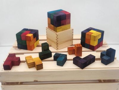 Colorful wooden puzzle cubes and pieces arranged on a wooden surface.