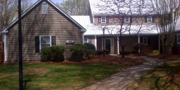 House with pathway and trees in the yard.