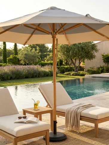 Poolside lounge chairs with umbrella and refreshing drink in a serene backyard.