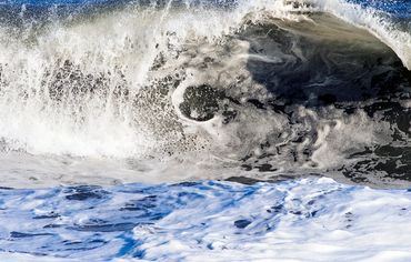 Hamptons ocean waves with blue sky reflecting on the water