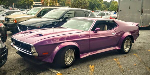 Purple classic muscle car parked in a lot.