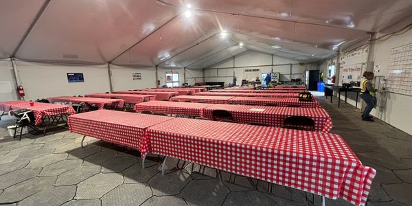 Image of a breakroom  with picnic tables and insulated roof and walls