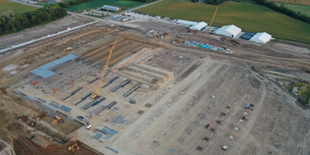 Aerial view of a large grassroots construction site with 3 clear span structures