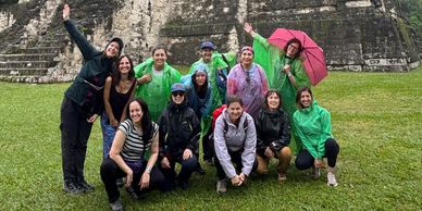 Grupo de amigos posando en una antigua pirámide en ruinas.