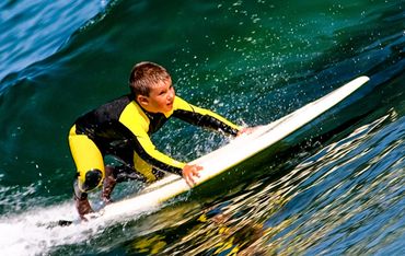 a boy surfing on a wave in the ocean 