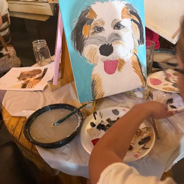 Painting of a happy dog on a canvas at a painting event. Paint your Pet night