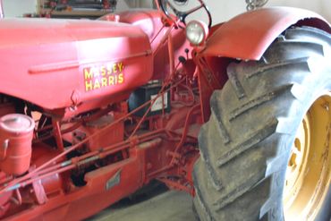 Close-up of a red Massey Harris tractor showing its large rear tire.