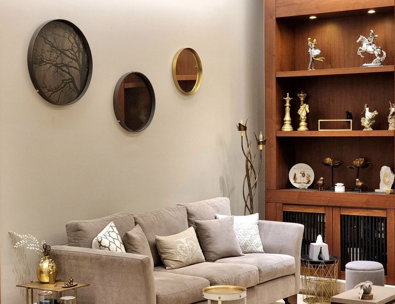 Cozy living room with beige sofa and decorative wall mirrors.