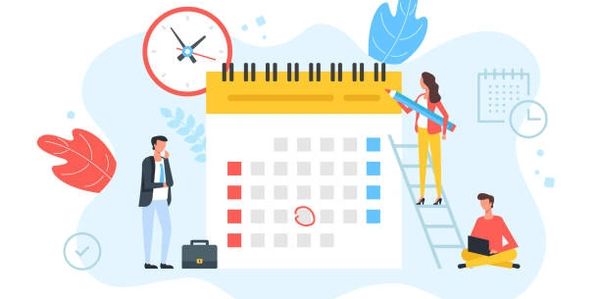 People organizing schedules around a large calendar.