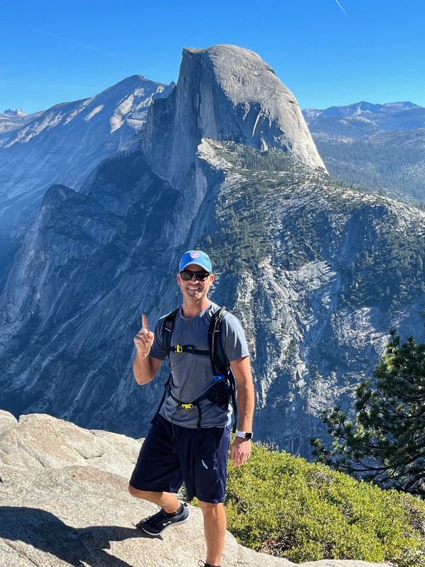 Chris Chandler hiking in Yosemite National Park with half dome in the background