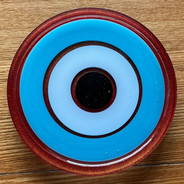 Close-up of a blue and red circular object on wood.