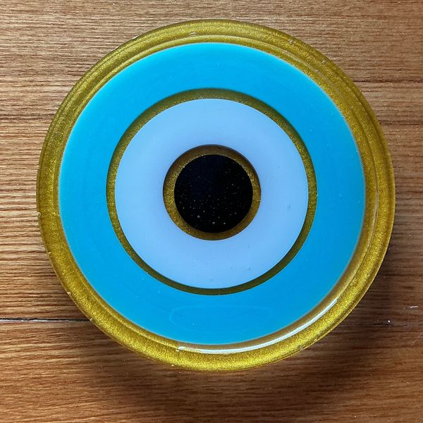 Circular object with concentric rings in gold, blue, white, and black.