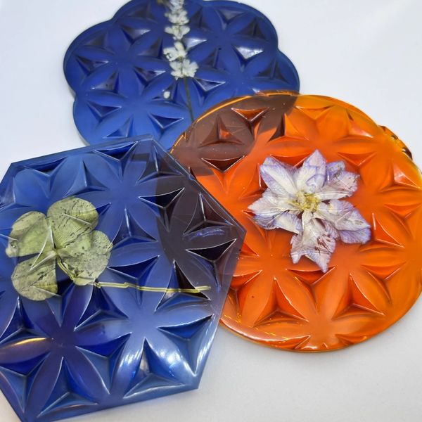 Decorative coasters with embedded flowers and geometric patterns.