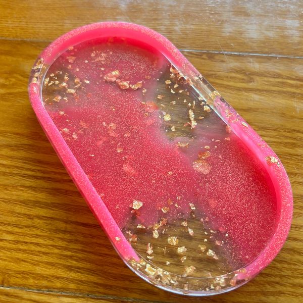 Pink and clear resin tray with glittering gold flakes.