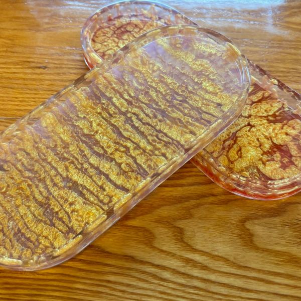 Two elegant glass trays with gold and amber designs.