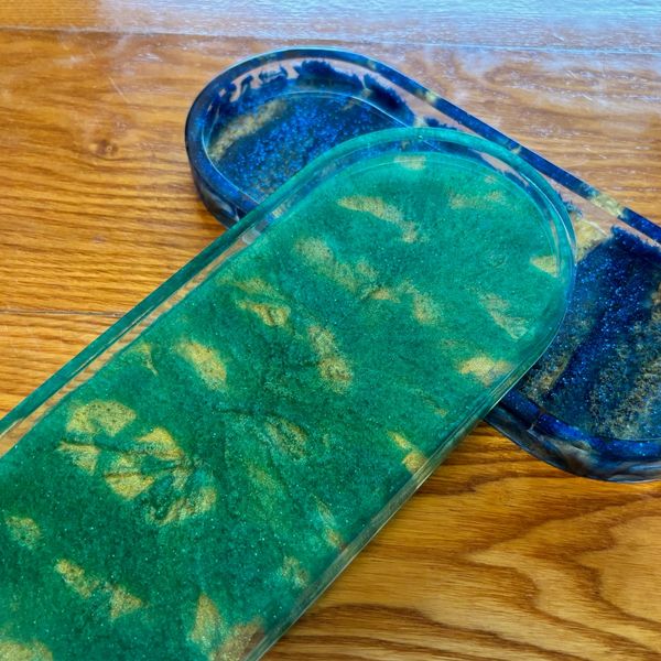 Two colored resin trays on a wooden surface.