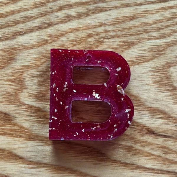 Red letter B on wooden surface.
