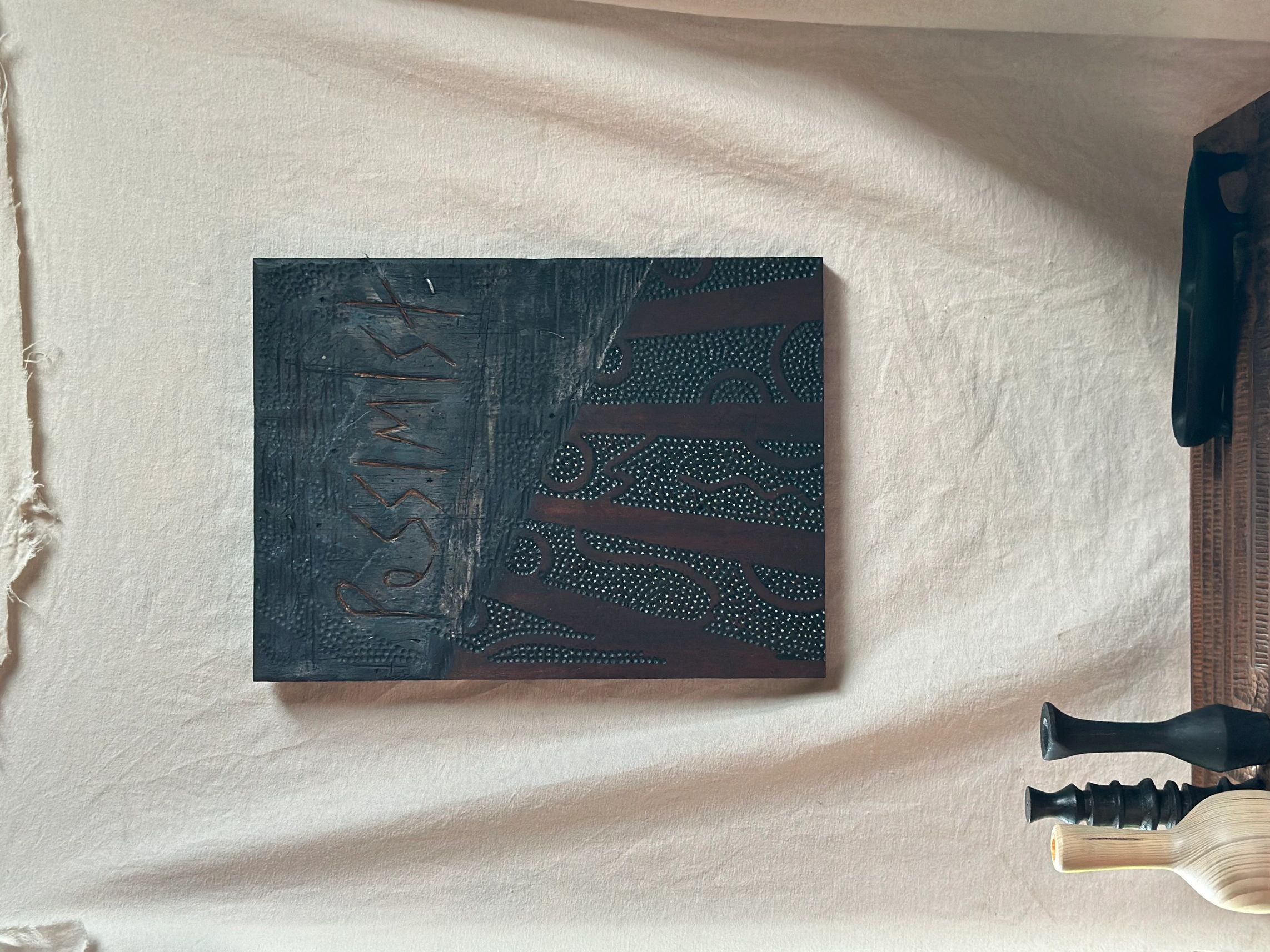 Dark abstract painting titled 'Pessimist' on a fabric backdrop.