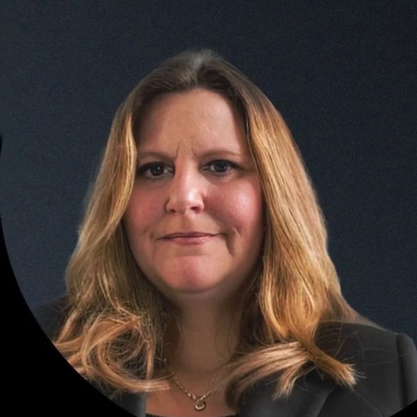 Professional portrait of a woman with blonde hair and a dark blazer.