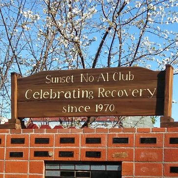 A serene landscape featuring a sunset over a calm lake with trees silhouetted against the colorful sky.