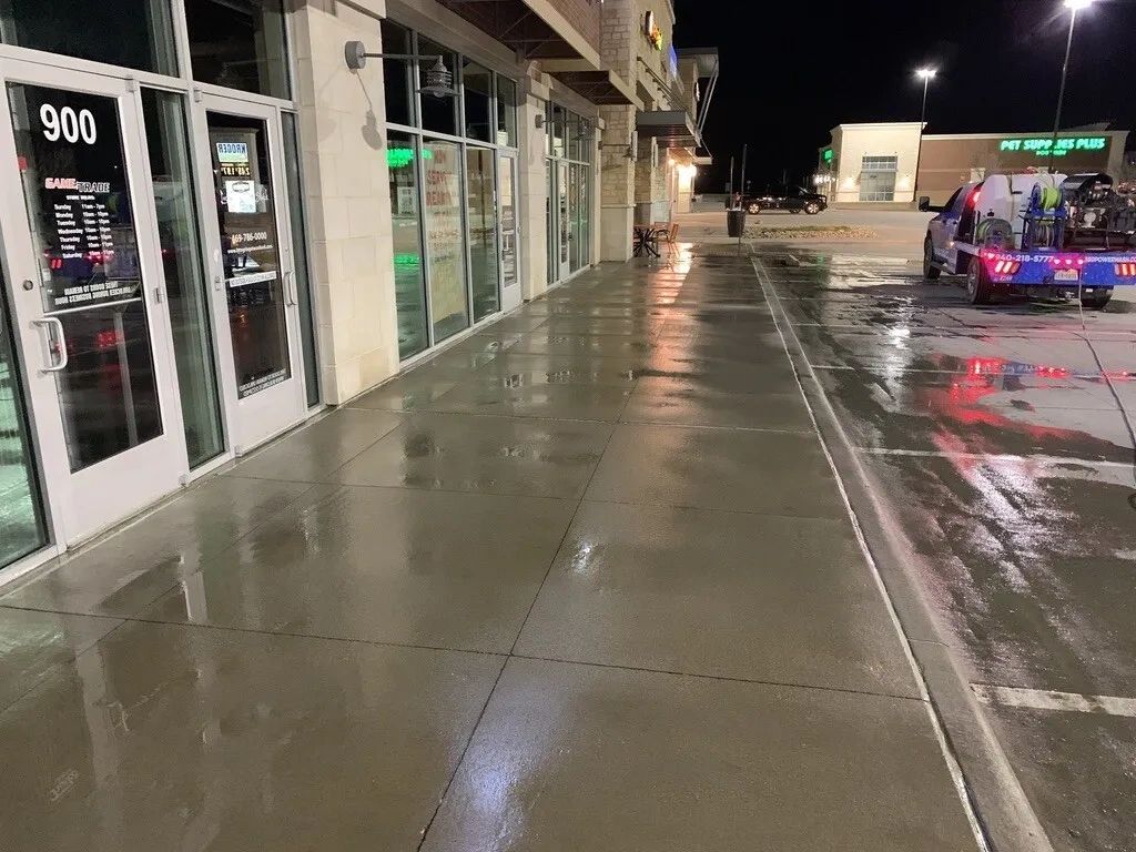 Retail shopping center, sweep the lot, power wash walls, hot wash walkways, dumpster, & dry windows.