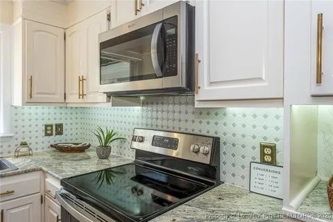 We maximized a small space with this modern kitchen upgrade: custom new wood cabinetry in a soft white lacquer for longevity and style is complimented by a whimsical tile backsplash tile with subtle pop of soothing ocean blue color weaved in and providing a waterproof barrier for culinary experimentation. The beautiful new storm grey granite with classic marbling is illuminated by bright undercabinet lighting, further refined by the soft and glamorous statement made by polished gold cabinet hardware. This magnificent, practical, and inviting kitchen is finished off with new stainless steal appliances. Vankirk Home Upgrades specializes in maximizing small spaces by improving flow and layout, the addition of custom built-ins and specialized carpentry solutions, pantry additions, and customizations, unique organizers, and one-of-a kind cabinet layouts and interior features that are unmatched, and specifically tailored to your needs.