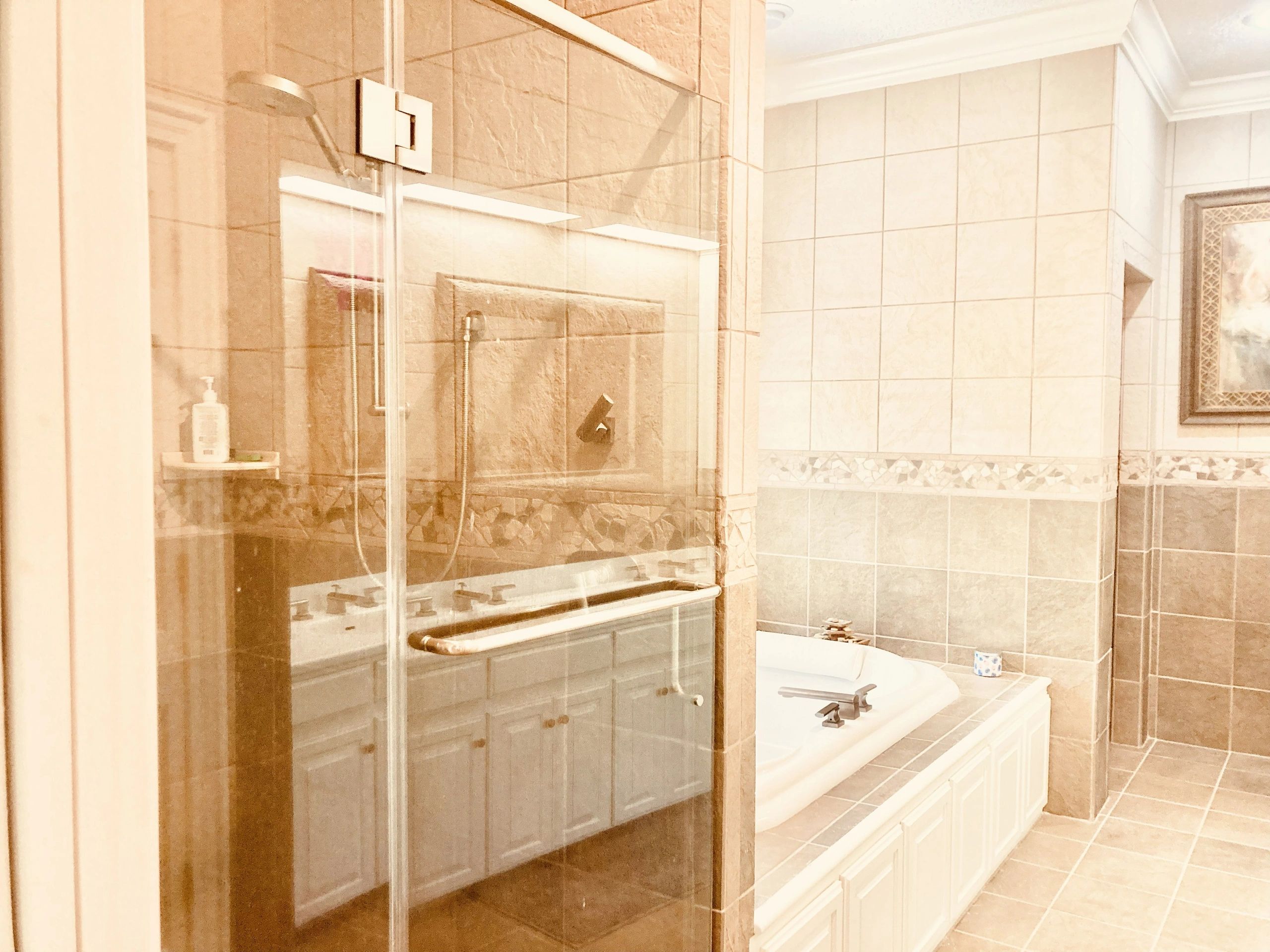 With luxurious floor-to-ceiling tilework, crown molding, huge / oversized two-person jetted soaking tub, large rain shower with glass enclosure, and private toilet area beyond the bath, this is one of Vankirk Home Upgrades' favorite primary bathrooms. It is a private and peaceful oasis, and represented a homeowners' long-awaited dream-come-true home spa sanctuary.