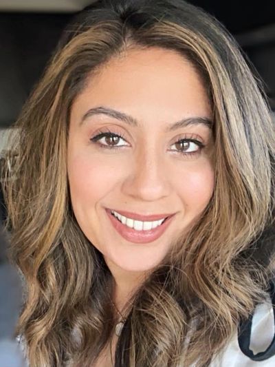 A smiling woman with wavy highlighted hair.