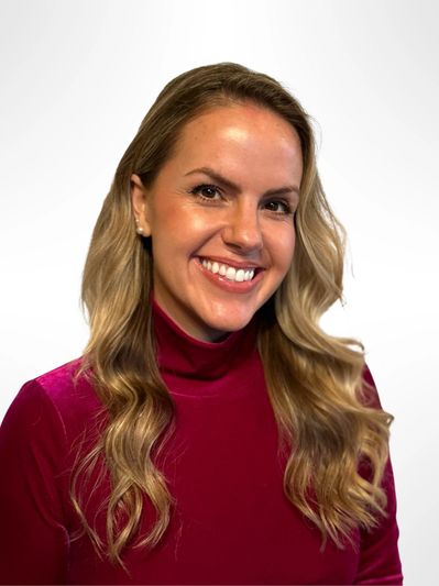 Smiling woman with long blonde hair in a red top.