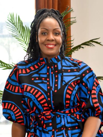 Smiling woman in a vibrant, patterned dress.