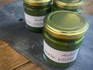 Three jars of garlic paste with gold lids.