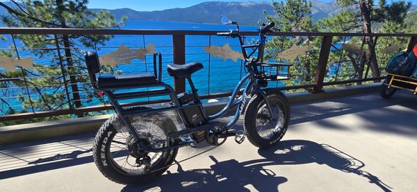 Electric bike parked on a deck overlooking a lake and mountains.
