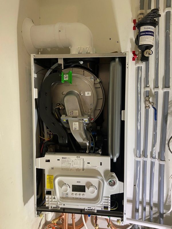 Open boiler unit with visible internal components and connected pipes.