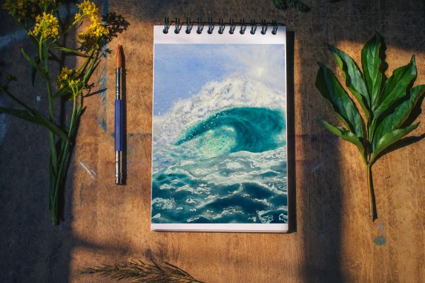 Sketchbook showing a watercolor wave painting.
