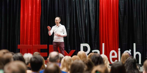 Speaker presenting at TEDx Raleigh event.