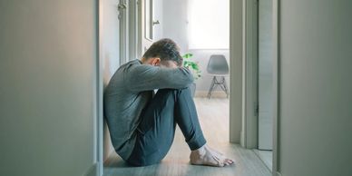 Person sitting alone, looking sad.