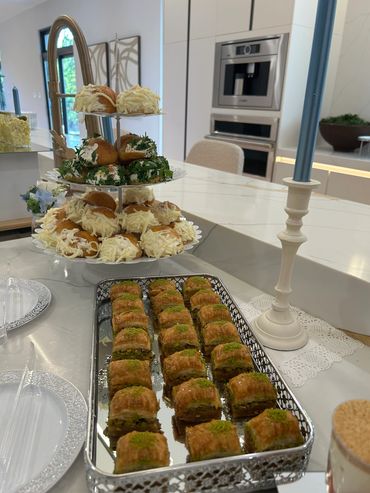 Elegant dessert spread on a modern kitchen island with pastries and blue candles.