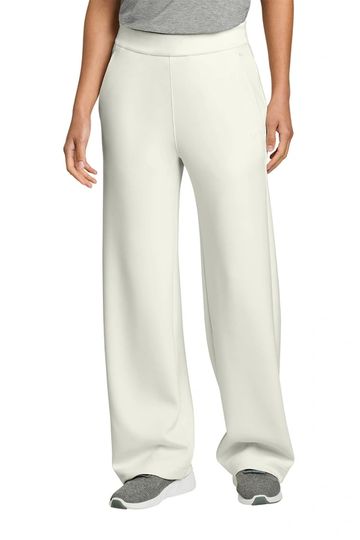 Woman wearing white wide-leg pants with gray sneakers and a gray top.