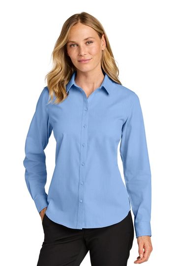 Woman wearing a light blue button-up shirt and black pants.