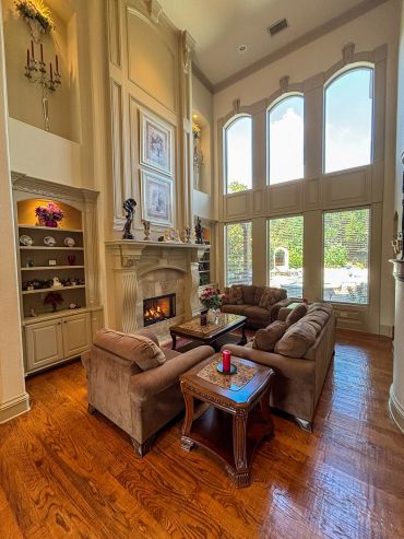 Elegant living room with tall windows and cozy fireplace.