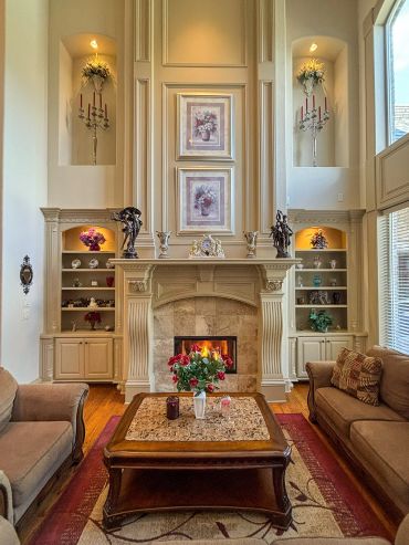 Elegant living room with a grand fireplace, cozy sofas, and floral decor.