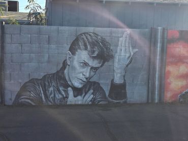 Black and white mural of a man on a brick wall.