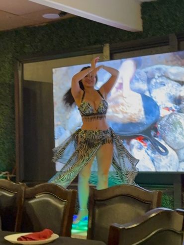 Dancer performing in a leopard print outfit indoors.