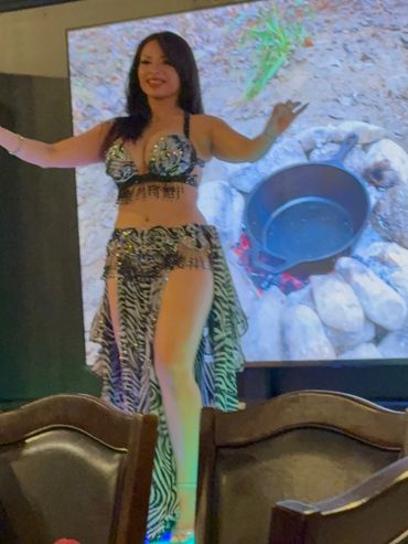 Woman performing belly dance on stage.