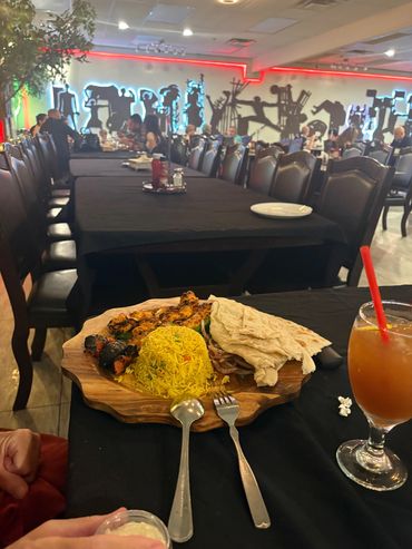 A meal with rice, bread, and grilled meat in a restaurant.