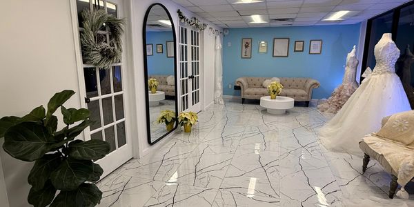 Elegant bridal boutique with white marble floors and wedding gowns.